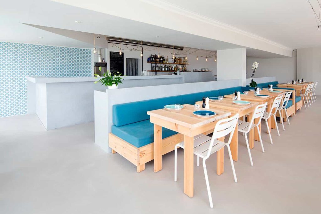 Interieur du pool-house canapé bleu, chaises et bar