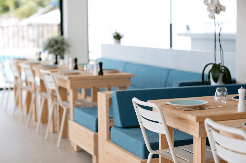 Canapé bleu et chaise blanche du Pool house interieur de l'hôtel sur fond flou